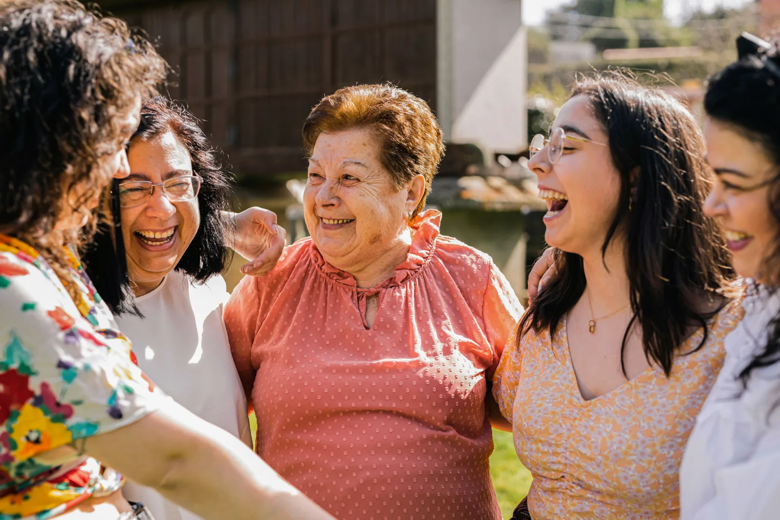 Una abuela riendo con las mujeres de su familia, abrazadas